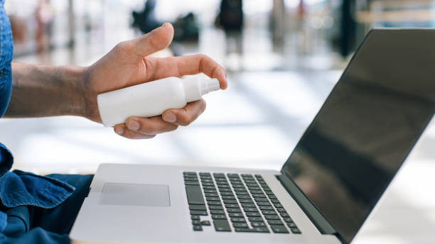istock young man decontaminating his laptop with antiseptic 1250407401