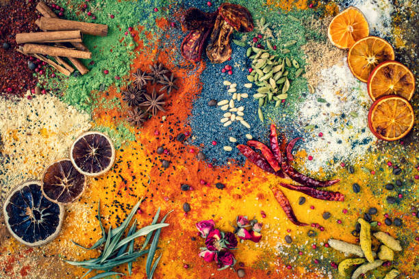 Many multi colored spices and dried fruits on the table.