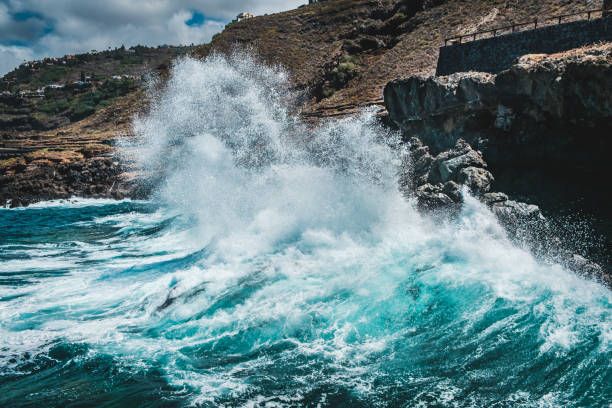 big wave crushing on rocky coast - waves hit rocks on shore -