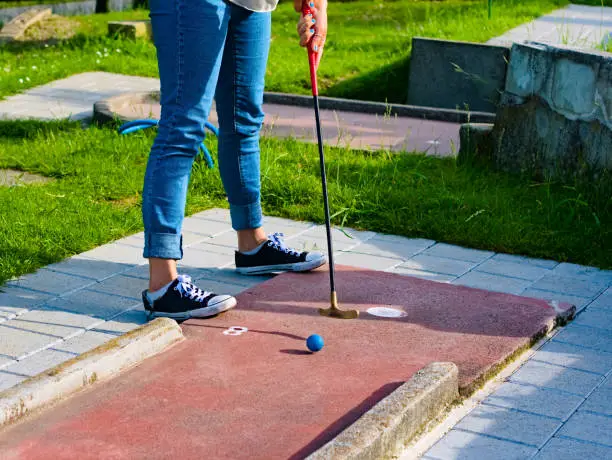 A woman at the starting point of a minigolf course