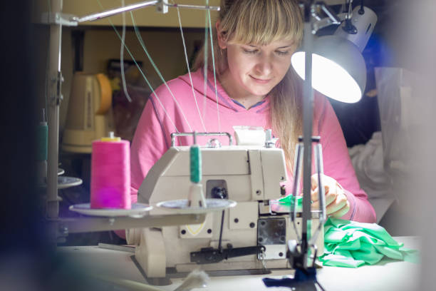 istock Girl works by light lamp behind industrial sewing machine 1250419137