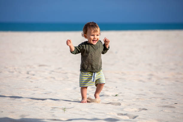 Smiling baby enjoying his first time on the beach