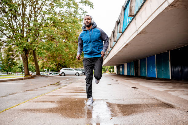 istock Young man running over the puddle by the garages 1250426813