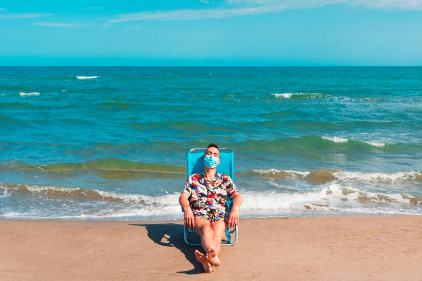 man wearing a surgical mask on the beach