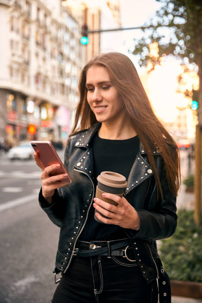 istock Blonde girl looking at phone with a coffee. 1250431634