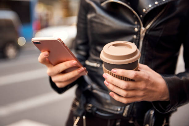istock Hands with a phone and coffee.Close up shot. 1250432093