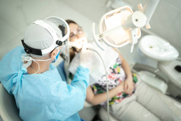 dentista sénior examinando los dientes de una mujer joven - medical exam dental hygiene caucasian mask fotografías e imágenes de stock