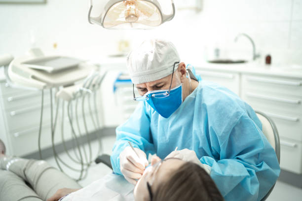 若い女性の歯を調べる上級歯科医 - dentist dentists chair men confidence ストックフォトと画像