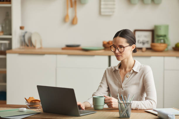 istock Elegant Woman Working at Kitchen Table 1250438594