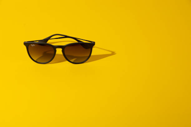 istock Stylish Sunglasses on Bright Yellow Background Under the Sunlight. 1250438809