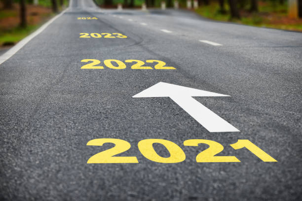 Number of 2021 to 2024 on asphalt road surface with white arrow stock photo