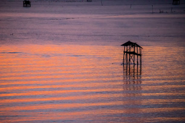 Silhouette of bamboo cottage with morning sunshine in gulf of Thailand at Bang Tabun, Phetchaburi, Thailand.