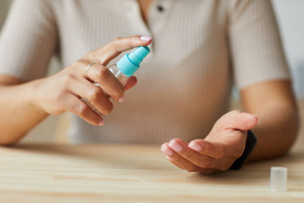 istock Woman Spraying Sanitizer on Hands Close Up 1250440344