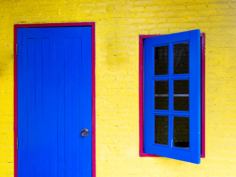 The Blue Wooden Window and Door on The Red Frame in The Yellow Wall in The House
