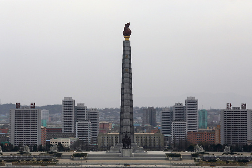 April 13, 2018. Pyongyang, North Korea. \nThe 170-meter-long tower, named after the Juche philosophy, can be seen from all over the city. In front of the tower there is a bronze statue with a height of 30 meters, three people carrying a sickle, hammer and writing brush. The tower is the most suitable place to see all parts of the city.