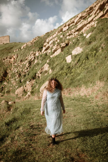 istock Young woman walking in a field 1250446496