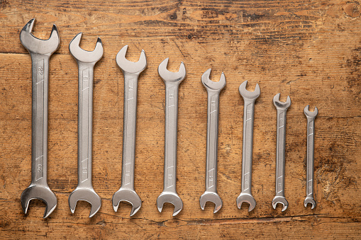 Eight wrench keys on a vintage wooden background