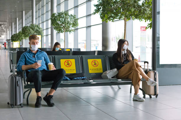 pasajeros con máscara facial n95 esperando en el área del aeropuerto - banco asiento fotografías e imágenes de stock