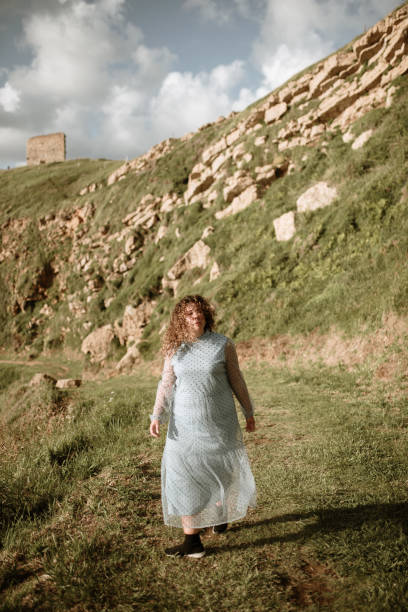 istock Young woman walking in a field 1250446683