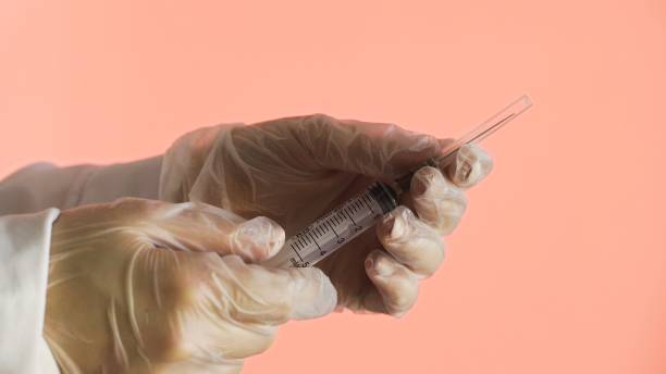 istock Doctor open needle and sprinkling medicines on a pink background 1250451534