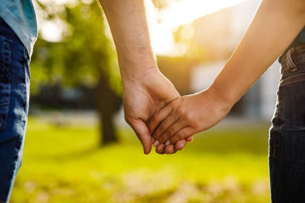 istock Couple holding hands while walking through the park. Close up. 1250451929