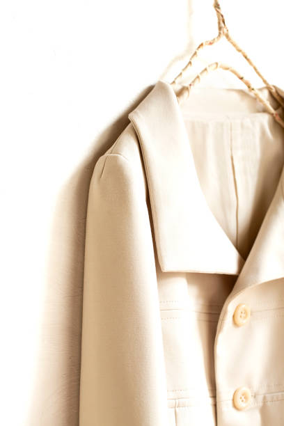istock beige or white jacket hanging on clothes hanger on white background. 1250453859