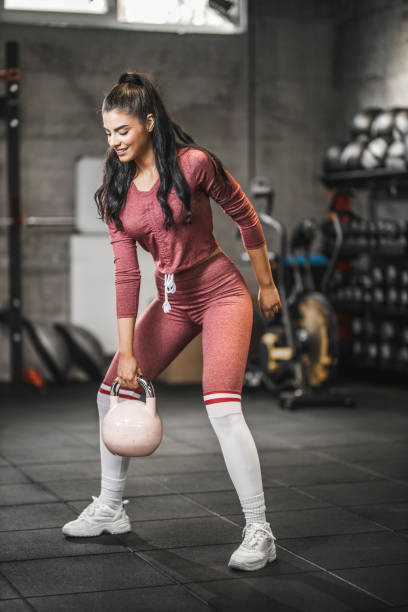 sporty girl lifting kettlebell during strength training exercising - kettle bell activity aerobics athlete imagens e fotografias de stock