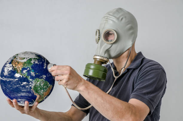 istock Man with gas mask holding Earth with stethoscope 1250455158