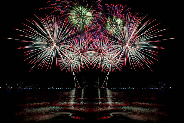 istock Beautiful colorful firework display over sea on celebration night. Firework festival showing on independence day or happy new year. 1250455199