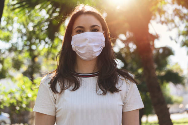 istock Young woman looking at camera wearing protective face mask. 1250455200