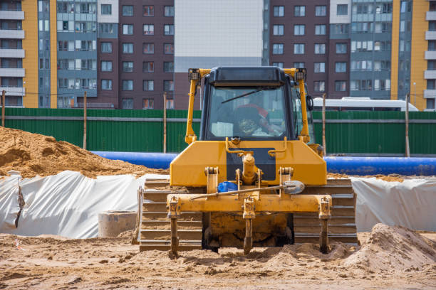 istock Heavy bulldozer back view on the construction of sewage and heating communications under the road, amid multi-story residential buildings. 1250455215