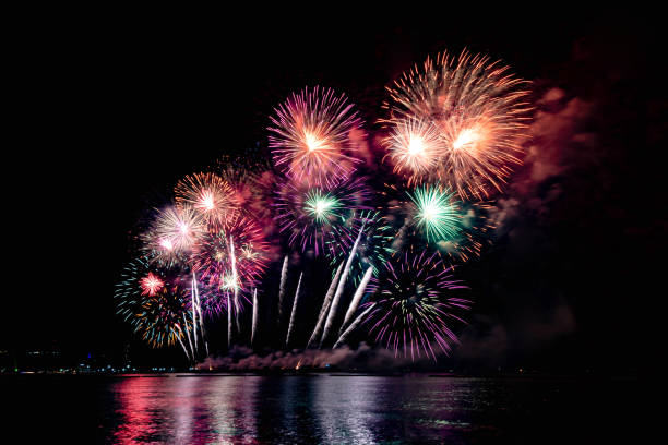 istock Beautiful colorful firework display over sea on celebration night. Firework festival showing on independence day or happy new year. 1250455224