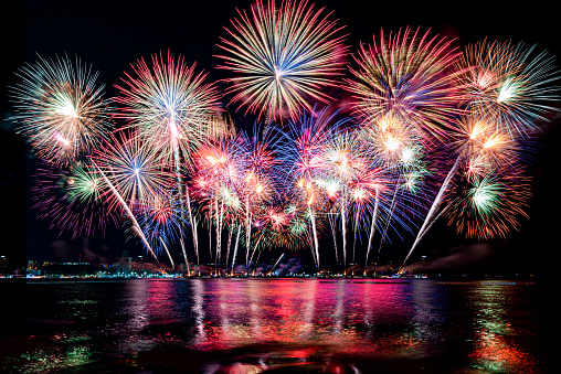 Beautiful colorful firework display over sea on celebration night. Firework festival showing on independence day or happy new year.