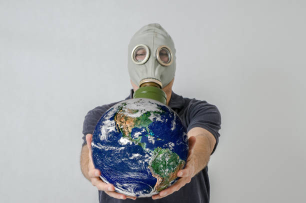 istock Man with gas mask holding Earth 1250455357