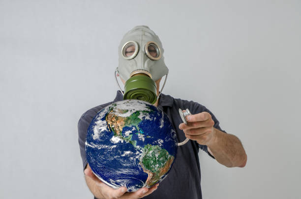 istock Man with gas mask holding Earth with stethoscope 1250455685