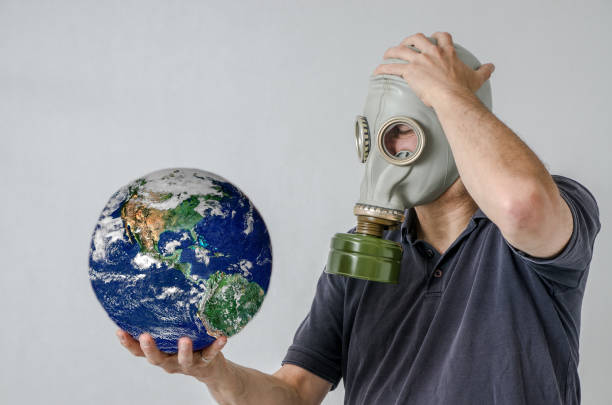 istock Man with gas mask holding Earth 1250455752