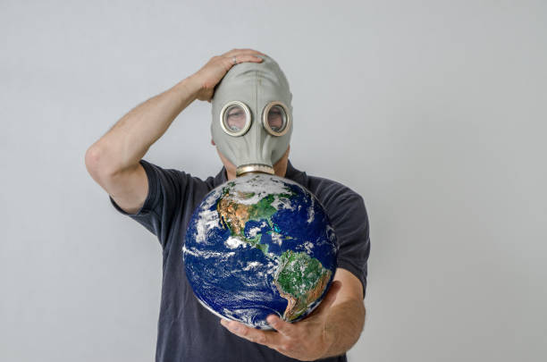 istock Man with gas mask holding Earth 1250455773