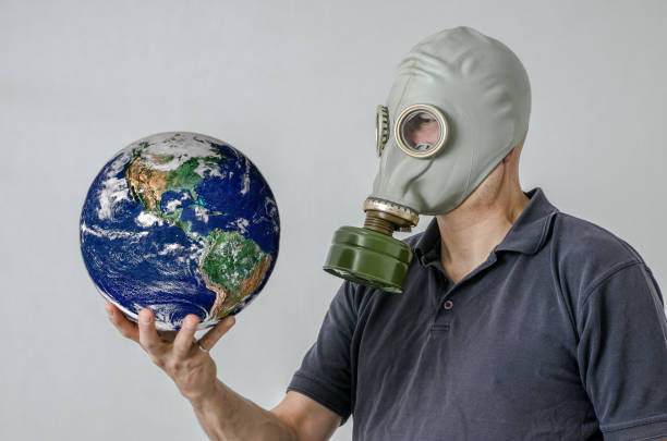 istock Man with gas mask holding Earth 1250455800