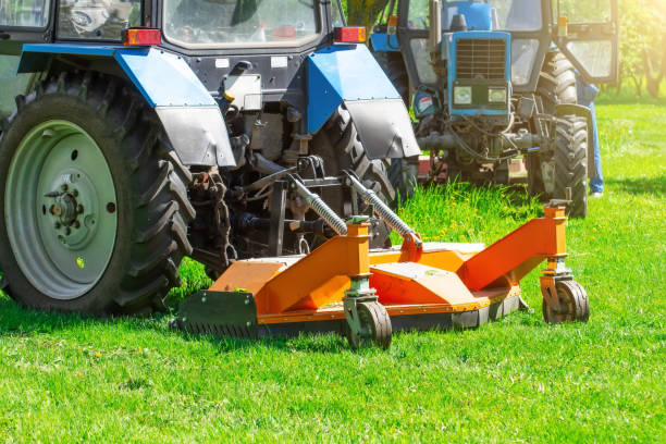 istock Tractor uses trailed lawn mower to mow grass on city lawns, back view. 1250455829