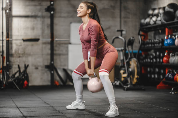 istock Sporty girl lifting kettlebell during strength training exercising 1250459046