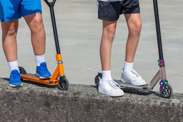 istock children's feet on multi-colored scooters, two children, close-up 1250464781