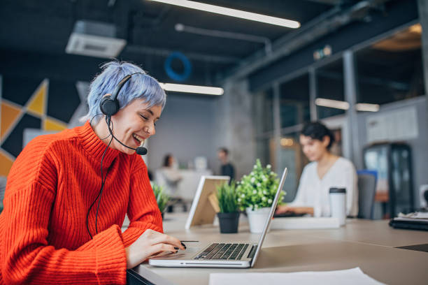 Woman with headset in big modern office Group of people, business people working all together in modern office. purple hair stock pictures, royalty-free photos & images