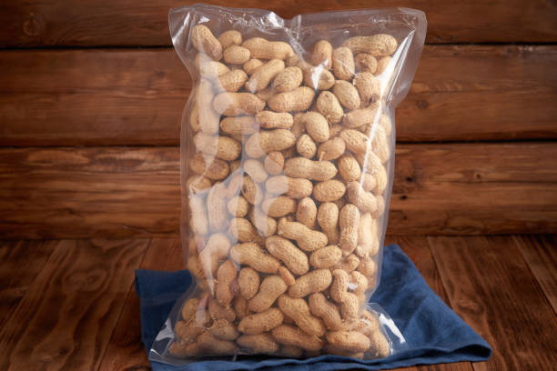 istock Organic dried fruits - peanuts in shells in packaging on a textural design background and linen. Vegetarian food. 1250467060