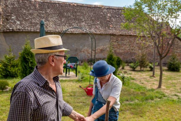 庭に植える笑顔のシニアカップル - women senior adult italy dirty ストックフォトと画像