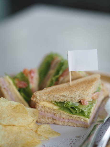 petit déjeuner sandwich howe pain farci au jambon et laitue salade légumes croustilles, bâton blanc drapeau sur la nourriture - toast portion club sandwich cafe photos et images de collection