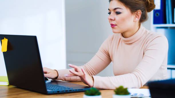 istock Positive girl typing on laptop in office 1250470138
