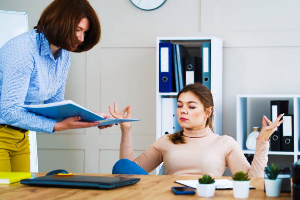 istock Office girl ignoring angry boss and meditating at workplace 1250470240
