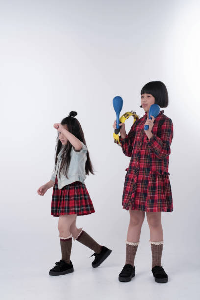 istock Elder sister playing Maracas,Younger sister dancing beside,doing activity together 1250470982
