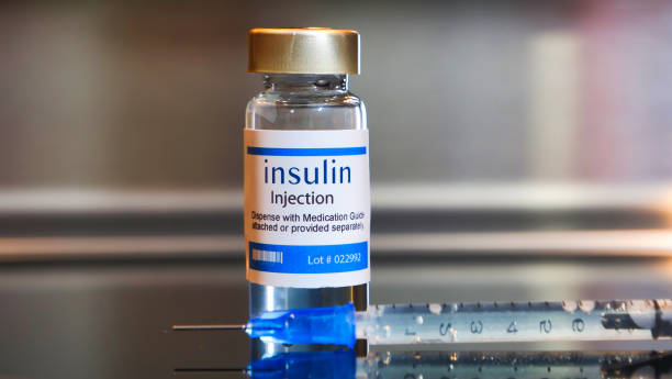 Vial of insulin injection with a syringe on black table and stainless steel background. Bottle of insulin injection with a syringe on black table and stainless steel background. insulin stock pictures, royalty-free photos & images