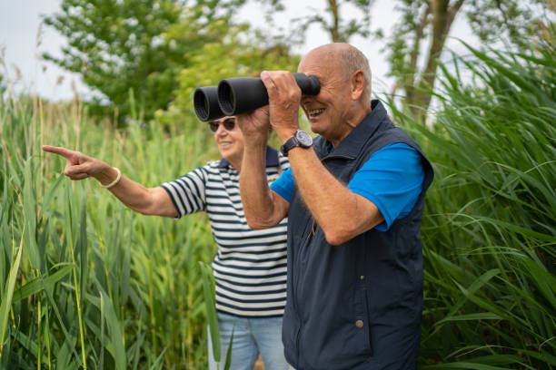 istock happy seniors watching birds in nature reserve 1250472644